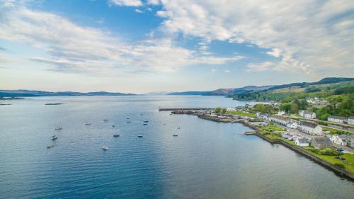 una vista aérea de una gran masa de agua con barcos en The Corran, en Lochgilphead