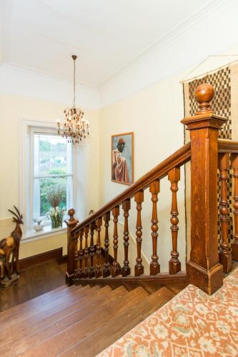 a wooden staircase in a home with a chandelier at The Corran in Lochgilphead