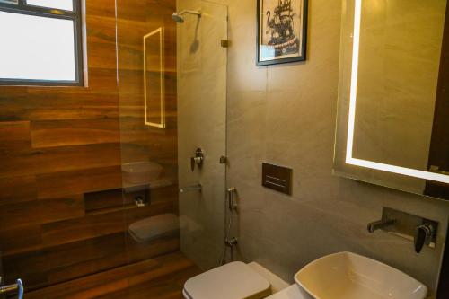 a bathroom with a shower and a toilet and a sink at Four Leaf Hotel - Sapphire Blue, Varanasi in Varanasi