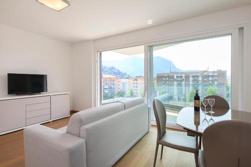un soggiorno con divano e tavolo con TV di Roggia 16 by Quokka 360 - central flat with balcony a Viganello