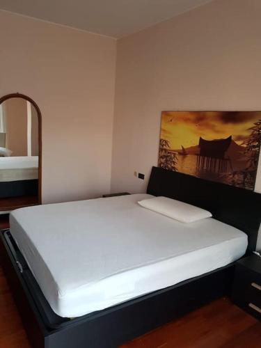 Una cama blanca en una habitación con un cuadro en la pared en Appartamento bello a Milano, en Milán