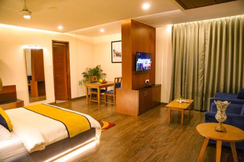 Four Leaf Hotel - Sapphire Blue, Varanasi في فاراناسي: غرفة فندق فيها سرير وتلفزيون