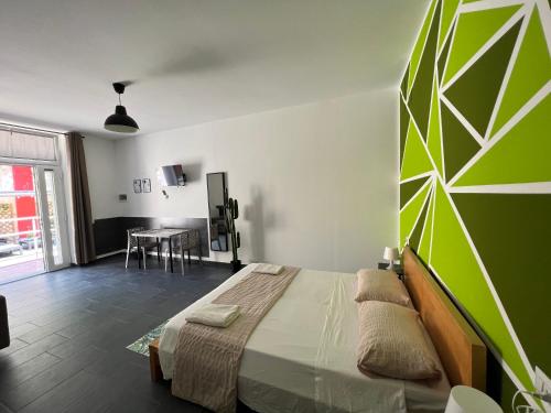 a bedroom with a large bed with a green wall at Hostel Turin Metro Young in Turin