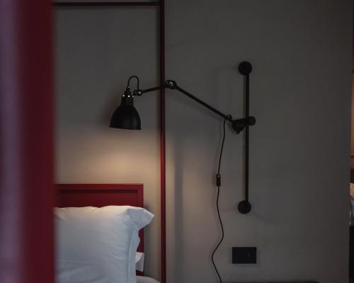 a black lamp in a bedroom next to a bed at Vocabolo Moscatelli in Calzolaro