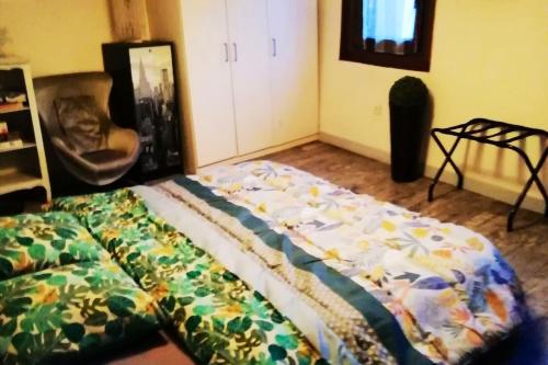 - une chambre avec un lit et une chaise dans l'établissement Maison de 2 chambres avec piscine privee jacuzzi et jardin clos a Wangen, à Wangen