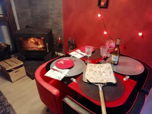 a table with a wine bottle and glasses and a fireplace at Maison de 2 chambres avec piscine privee jacuzzi et jardin clos a Wangen in Wangen