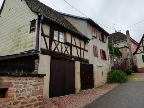 an old house with a garage in a street at Maison de charme à Wangen avec piscine privée et jardin in Wangen