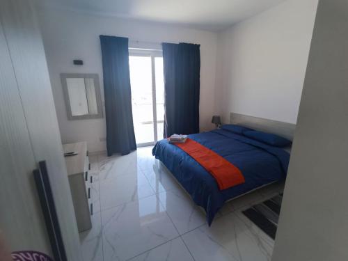 a bedroom with a bed with a blue and red blanket at Blu-M Central in Qormi
