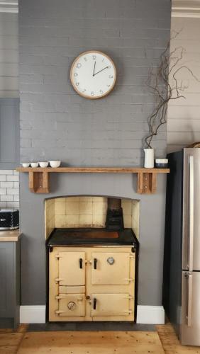 eine Uhr hängt an der Wand über einer Küche in der Unterkunft 'Pickett's Cottage' - Circa 1868 - Oldest in Knox! in Boronia