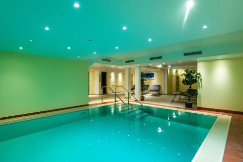 a swimming pool in a house with blue ceilings at Villa Auszeit Hotel Garni in Bansin