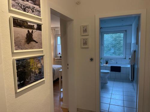 a bathroom with a toilet and a sink with pictures on the wall at Wohnung in Wuppertal Elberfeld in Wuppertal