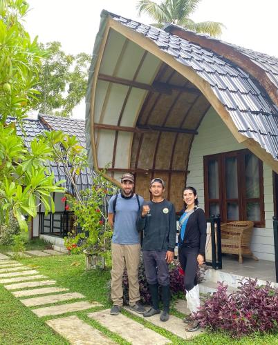a group of three people standing in front of a house at Gino's Place - Guest House & Jungle Trekking in Bukit Lawang