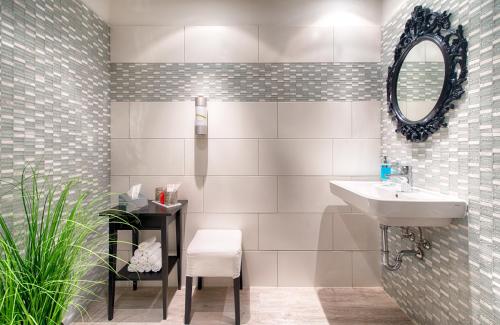 a bathroom with a sink and a mirror at Leonardo Inn Hotel Hamburg Airport in Hamburg