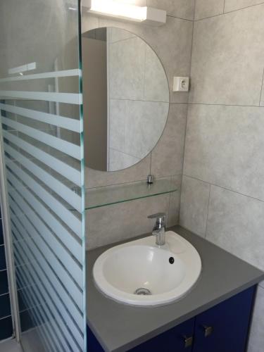 une salle de bain avec un lavabo et un miroir dans l'établissement Le Ker Bleu, à Perros-Guirec
