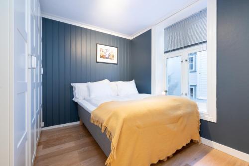 a bedroom with a bed with a yellow blanket at The Golden Lion Street Getaway in Trondheim