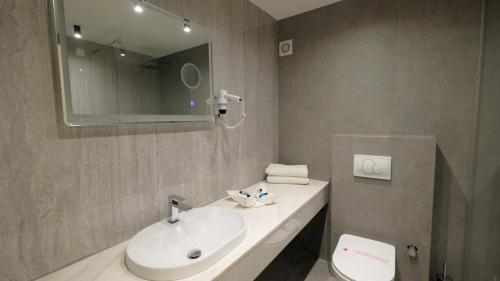 a bathroom with a sink and a mirror and a toilet at Hollywood Hotel in Sarajevo