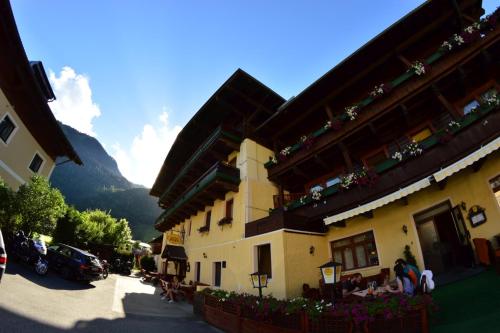 un grupo de personas sentadas fuera de un edificio en Hotel Post Fusch, en Fusch an der Glocknerstrasse