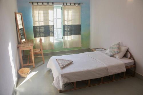 a small bedroom with a bed and a window at Ananda Tree House Eco Homestay in Kathmandu