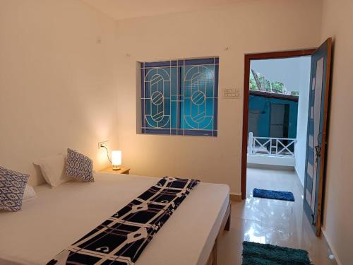 a bedroom with a bed and a glass window at Palm Heaven in Canacona