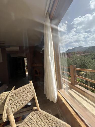 a wicker chair sitting on a balcony with a view at Bin Jbal Resort in Ouirgane