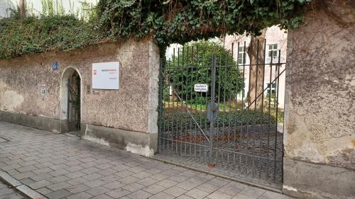 une clôture à côté d'un bâtiment avec un portail dans l'établissement Gästehaus der Katholischen Akademie, à Ratisbonne