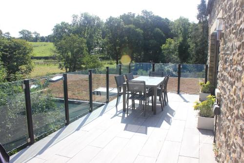 a patio with a table and chairs on a balcony at Riverbank Cottage in Lancaster