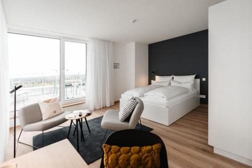 um quarto com uma cama branca e uma grande janela em The Place Herzogenaurach - Serviced Apartments em Herzogenaurach