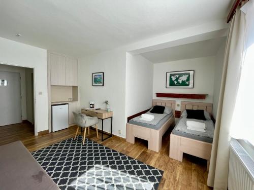 a small room with two beds and a table at Penzion U Přehrady in Luhačovice