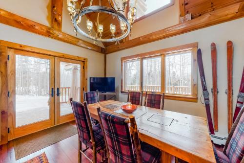 a dining room with a table and chairs and skis on the wall at Snow Lion in Carrabassett