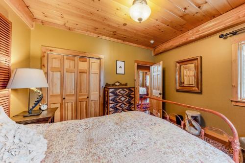 a bedroom with a large bed and a wooden ceiling at Snow Lion in Carrabassett