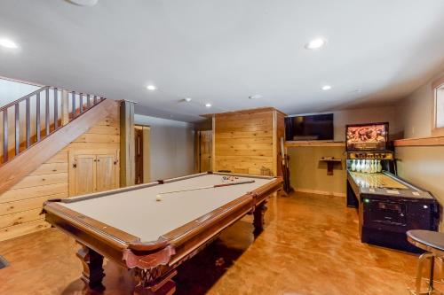 a large room with a pool table and a staircase at Snow Lion in Carrabassett