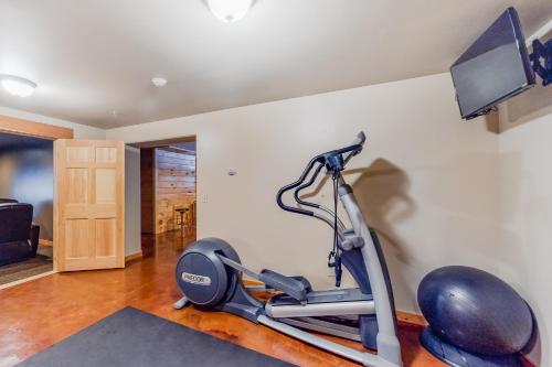 a gym with a treadmill and a flat screen tv at Snow Lion in Carrabassett