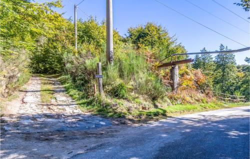 an empty road next to a forest with a fence at Gorgeous Home In Artò in Arola