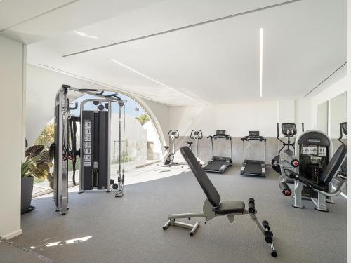 a gym with several treadmills and cardio machines at Kakkos Beach Hotel - Adults Only in Ierápetra