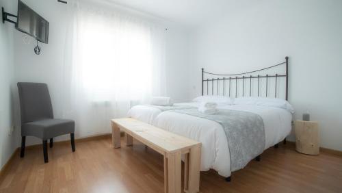 Un dormitorio con una cama, un escritorio y una silla. en Villa de Gredos, en Navarredonda de Gredos