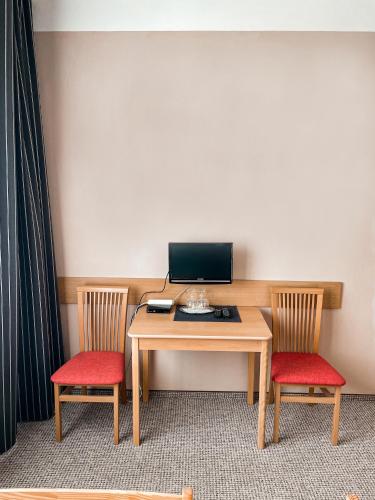 a desk with two chairs and a computer on it at JP ubytování Loštice in Loštice