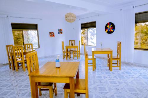 a dining room with wooden tables and chairs at Nature Kigali in Kigali