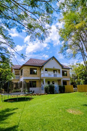 a large house with a yard with a grassy field at Nature Kigali in Kigali