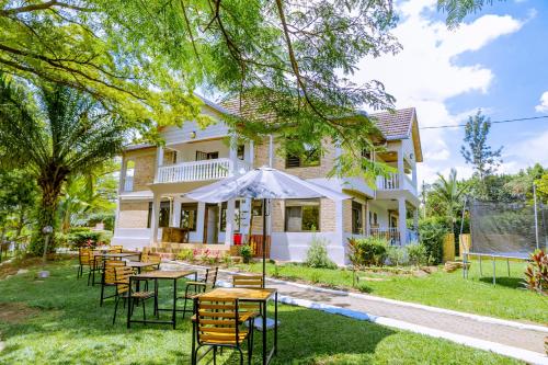 a group of tables and chairs in front of a house at Nature Kigali in Kigali