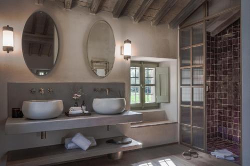 dois lavatórios numa casa de banho com dois espelhos em Vocabolo Moscatelli em Calzolaro