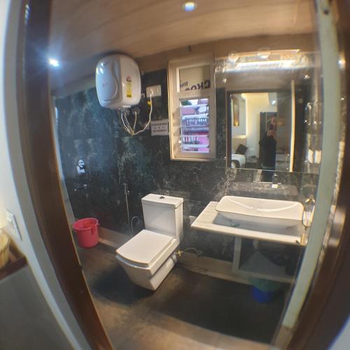 a bathroom with a white toilet and a sink at Zingo's Home Stay in Darjeeling