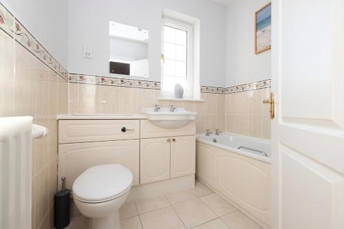 a bathroom with a toilet and a sink and a tub at JOIVY Modern flat with free parking in Edinburgh