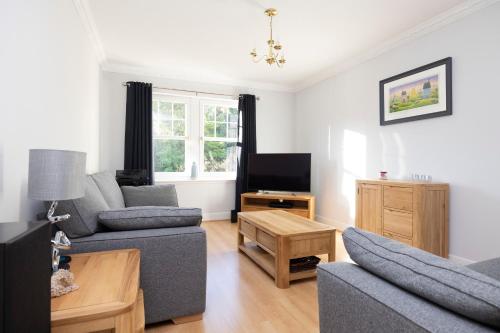 a living room with a couch and a tv at JOIVY Modern Flat with Free Parking in Edinburgh
