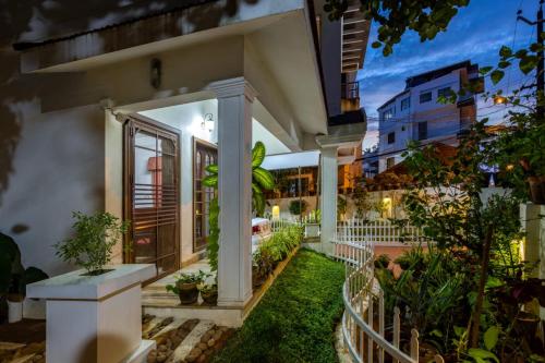 a house with a white fence and some plants at Homested Homestay Fort Kochi in Cochin