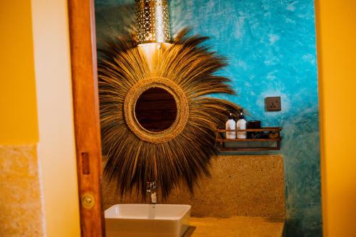a bathroom with a mirror and a sink at Mkunguni Villas in Bwejuu