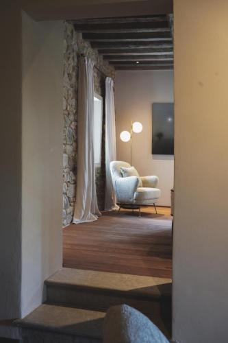 a living room with a chair and a television at Vocabolo Moscatelli in Calzolaro