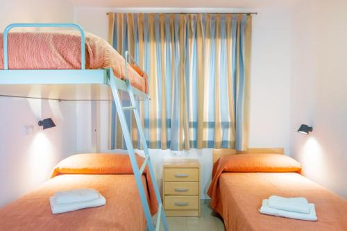 1 Schlafzimmer mit 2 Etagenbetten und einem Fenster in der Unterkunft Albergue Inturjoven Almeria in Almería