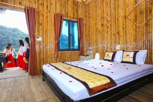 a bedroom with a large bed in a room with people at Hang Múa Lotus Homestay in Ninh Binh