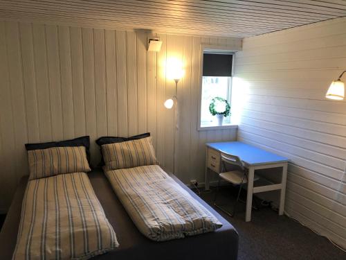 a room with two beds and a desk and a window at Spacious house in Tromsø, perfect for groups of families, tourists or workers in Tromsø