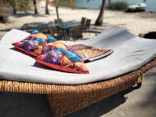 a wicker chair with a pillow on top of it at Shongili Island Lodge in Vila Praia Do Bilene